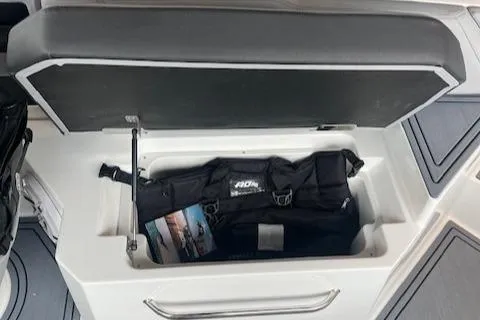 Slide: The Image of Storage compartment in 2025 Cobalt R6 Surf boat, containing a black bag and brochure. - 17