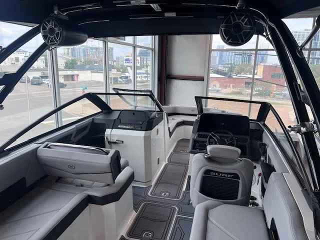 Slide: The Image of 2025 Cobalt R6 Surf boat interior with modern seating and dashboard in a showroom setting. - 23