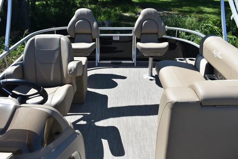 Slide: The Image of 2024 SunChaser Vista 20 Fish pontoon boat interior with beige seating and steering console. - 2