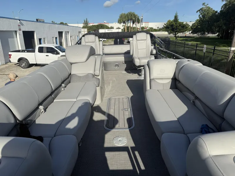 Slide: The Image of 2024 Regency 250 DL3 pontoon boat with spacious gray seating and modern design. - 13