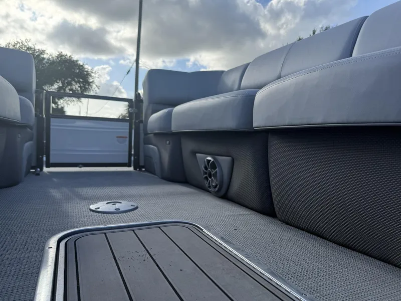 Slide: The Image of 2024 Regency 250 DL3 boat interior with plush seating and modern design under a cloudy sky. - 16