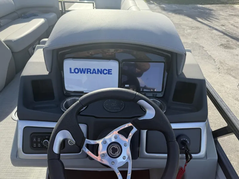 Slide: The Image of 2024 Regency 250 DL3 boat dashboard with Lowrance display and steering wheel. - 18
