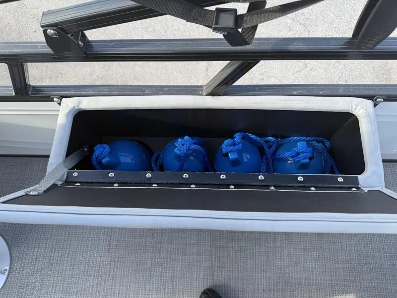 Slide: The Image of Storage compartment with blue fenders on a 2024 Regency 250 DL3 boat. - 28