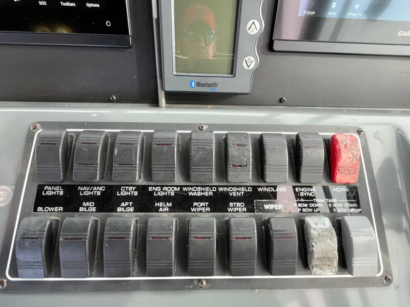 Slide: The Image of Control panel of a 2000 Tiara Yachts 3100 Open with labeled switches and buttons. - 13