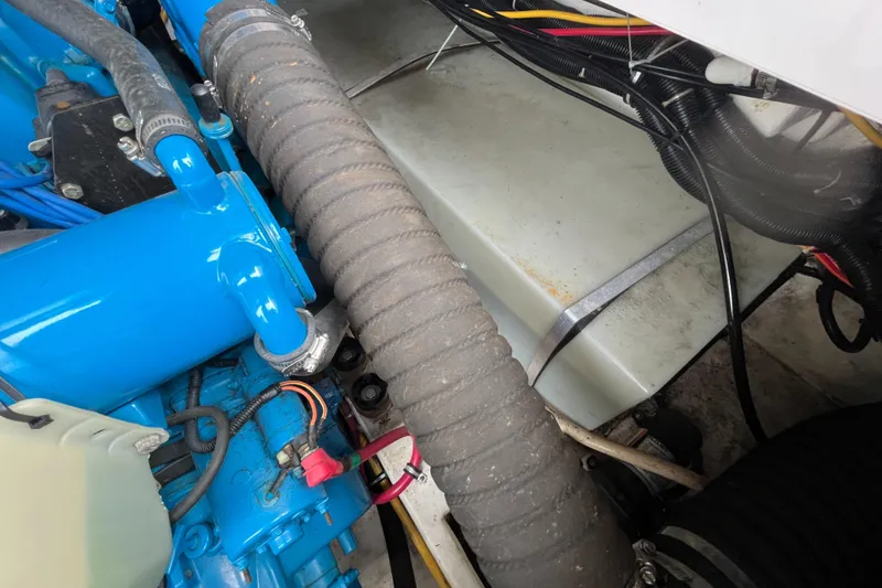 Slide: The Image of Engine compartment of a 2000 Tiara Yachts 3100 Open, featuring blue components and wiring. - 21