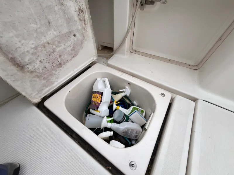 Slide: The Image of Storage compartment on a 2000 Tiara Yachts 3100 Open, filled with cleaning supplies. - 30