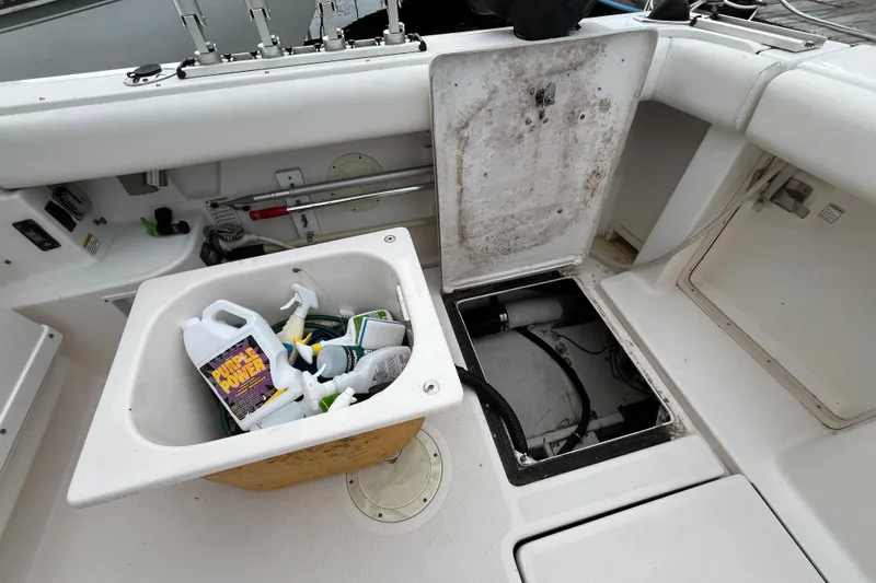 Slide: The Image of 2000 Tiara Yachts 3100 Open deck with cleaning supplies and open storage compartment. - 31