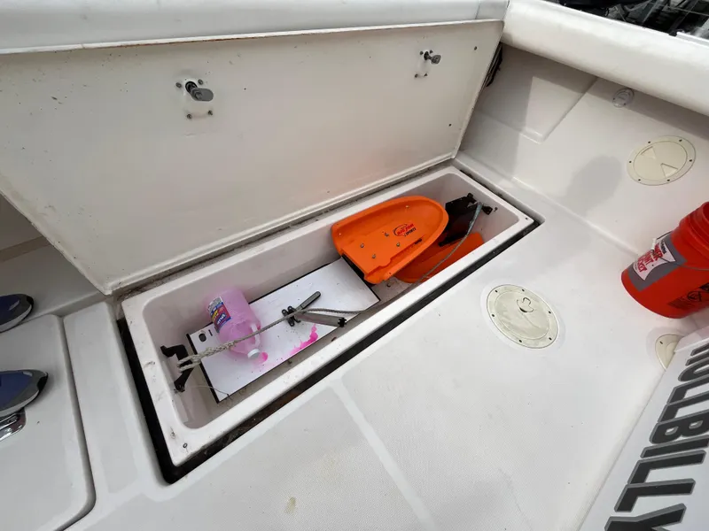 Slide: The Image of Open storage compartment on 2000 Tiara Yachts 3100 Open, containing safety equipment and cleaning supplies. - 35