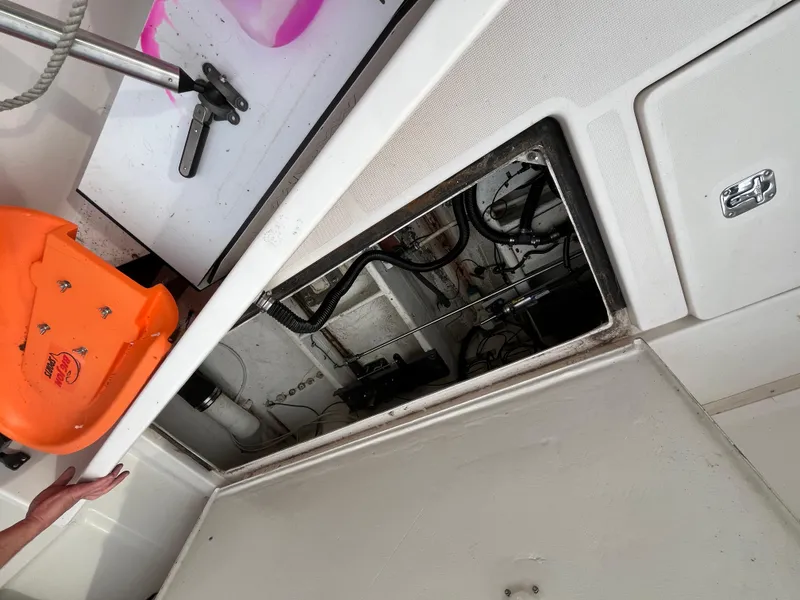 Slide: The Image of Engine compartment of a 2000 Tiara Yachts 3100 Open, showing mechanical components and orange safety equipment. - 36