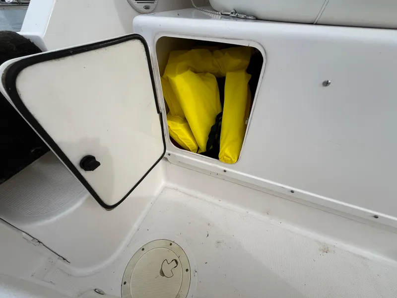 Slide: The Image of Open storage compartment on 2000 Tiara Yachts 3100 Open, containing yellow life jackets. - 41