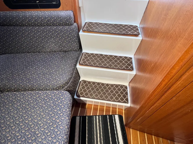 Slide: The Image of Interior of 2000 Tiara Yachts 3100 Open, featuring patterned stairs and cushioned seating. - 45