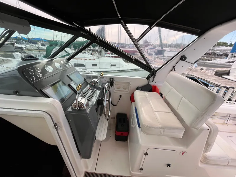Slide: The Image of 2000 Tiara Yachts 3100 Open helm with white seating and control panel. - 8