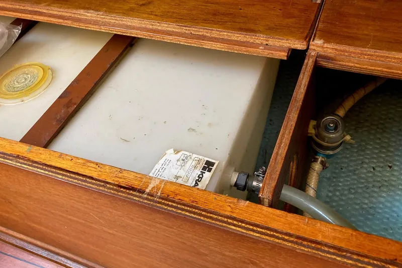 Slide: The Image of Wooden compartment with a water tank inside a 1982 Sabre 30 boat. - 15