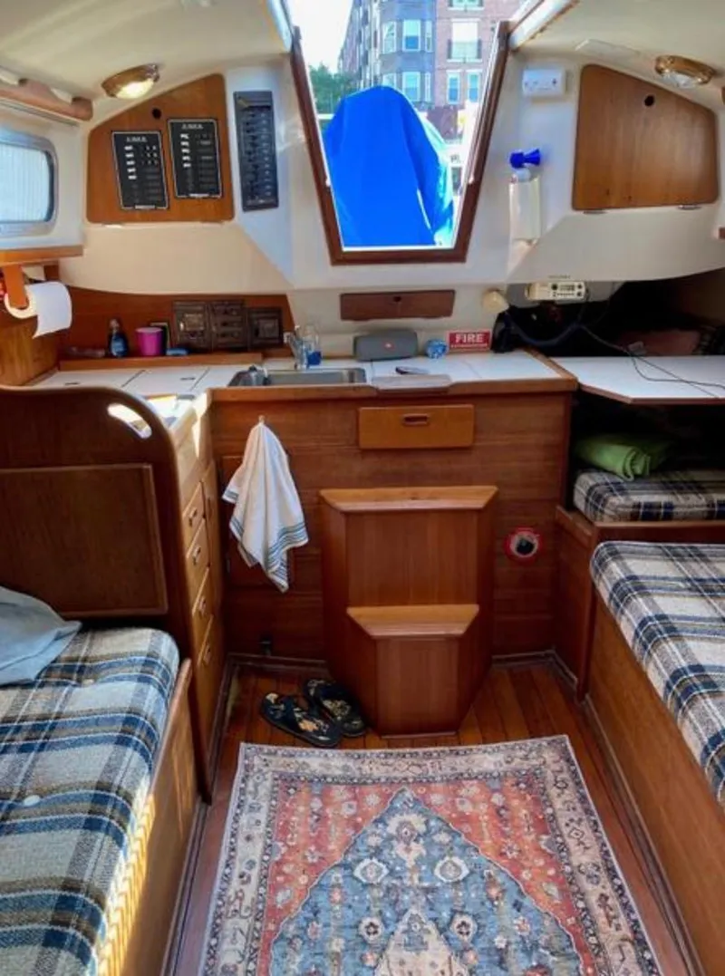 Slide: The Image of Interior of a 1982 Sabre 30 sailboat with cozy wooden furnishings and plaid seating. - 16