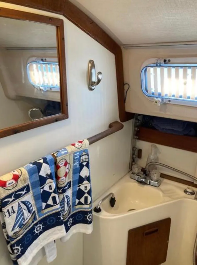 Slide: The Image of 1982 Sabre 30 sailboat bathroom with nautical-themed towel, mirror, and compact sink. - 18