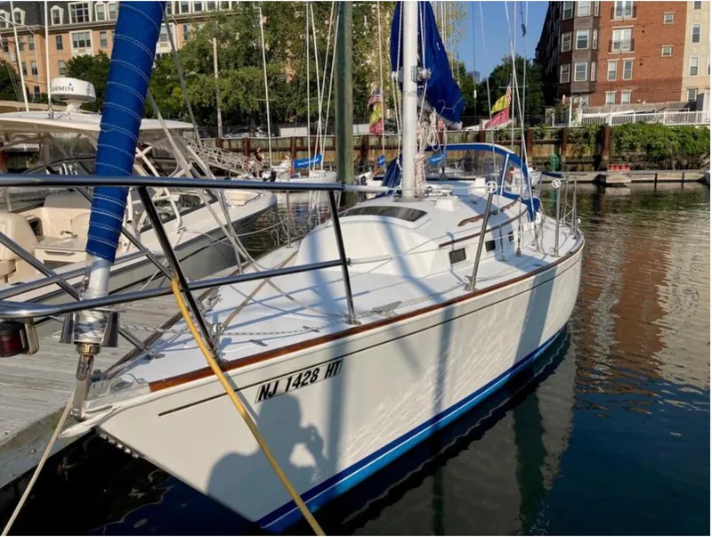 Slide: The Image of 1982 Sabre 30 sailboat docked in marina, surrounded by water and buildings. - 2