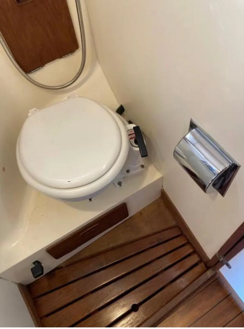 Slide: The Image of 1982 Sabre 30 yacht bathroom with marine toilet and wooden flooring. - 21