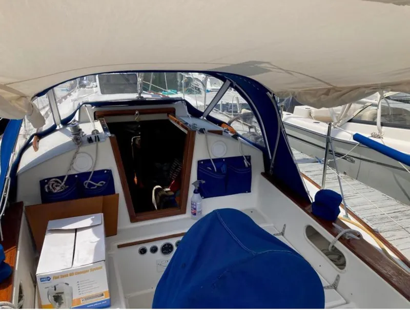 Slide: The Image of 1982 Sabre 30 sailboat cockpit with blue canopy and marina background. - 5