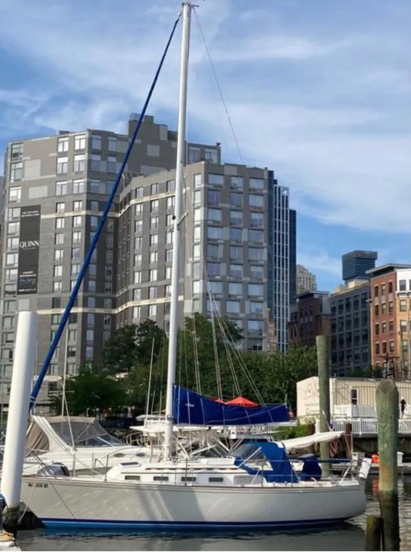 Slide: The Image of 1982 Sabre 30 sailboat docked in urban marina with modern buildings in background. - 9