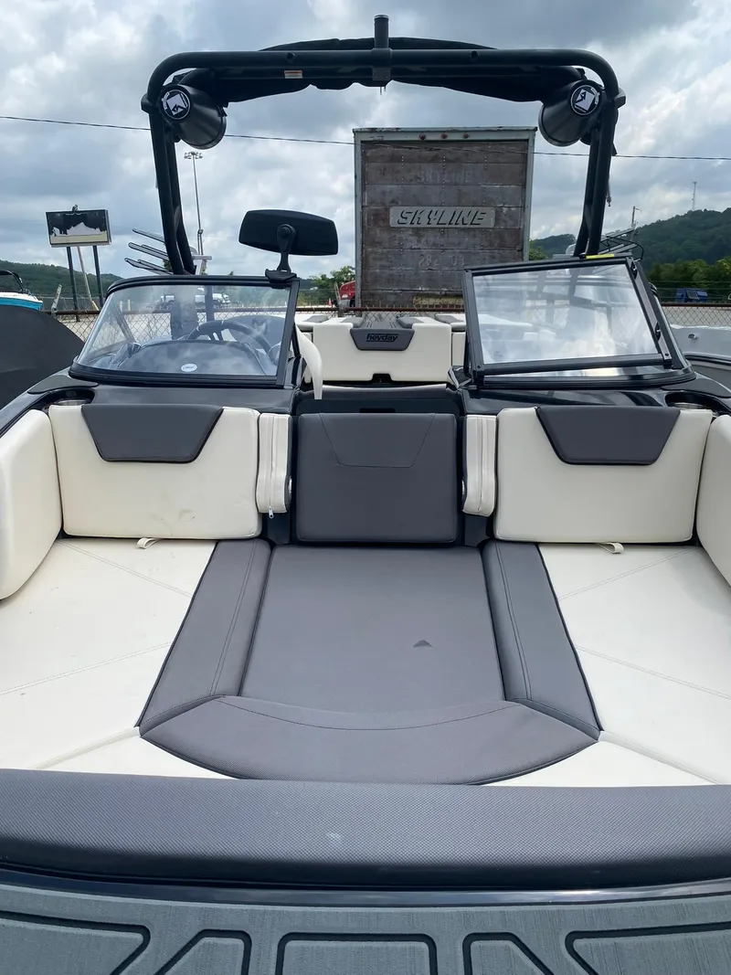 Slide: The Image of 2025 Heyday WTSurf boat interior with gray and white seating, open windshield, and overcast sky. - 10