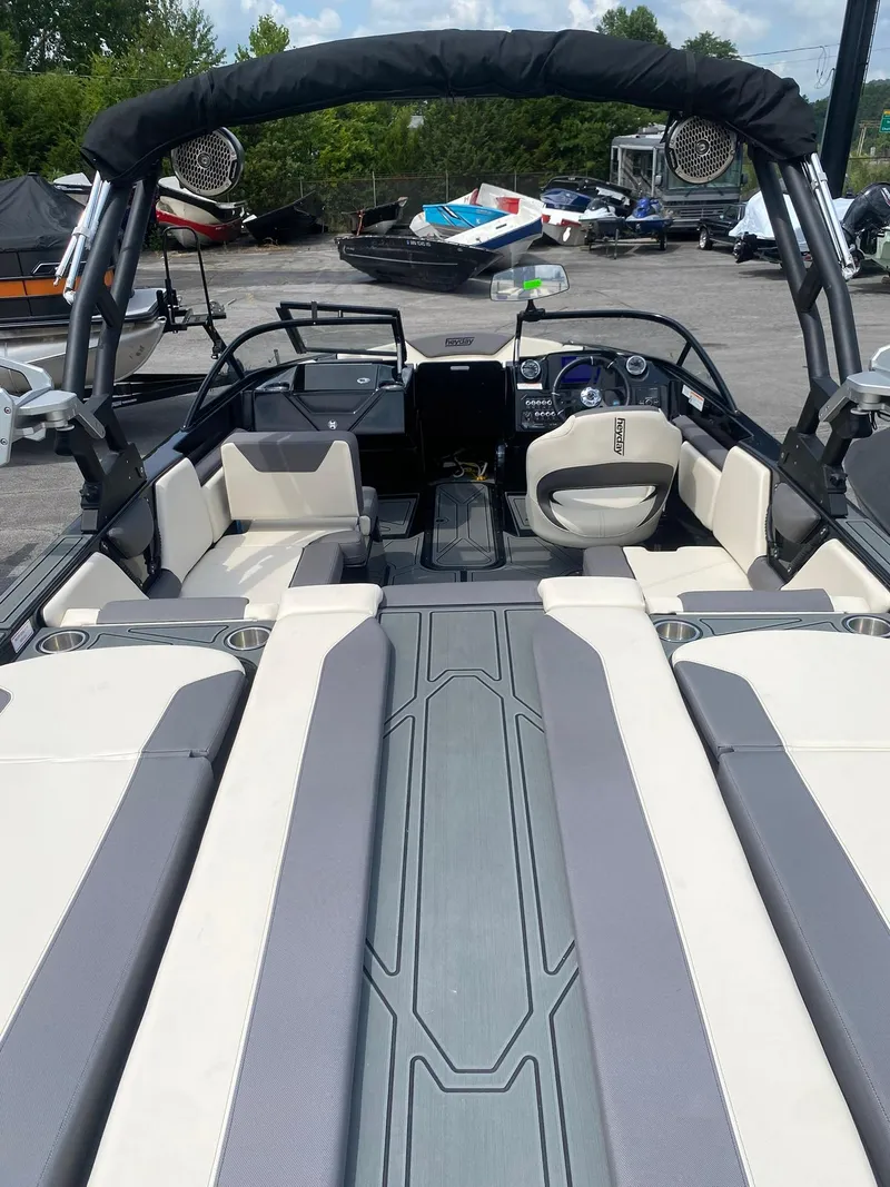 Slide: The Image of 2025 Heyday WTSurf boat interior with seating and dashboard, parked outdoors. - 14