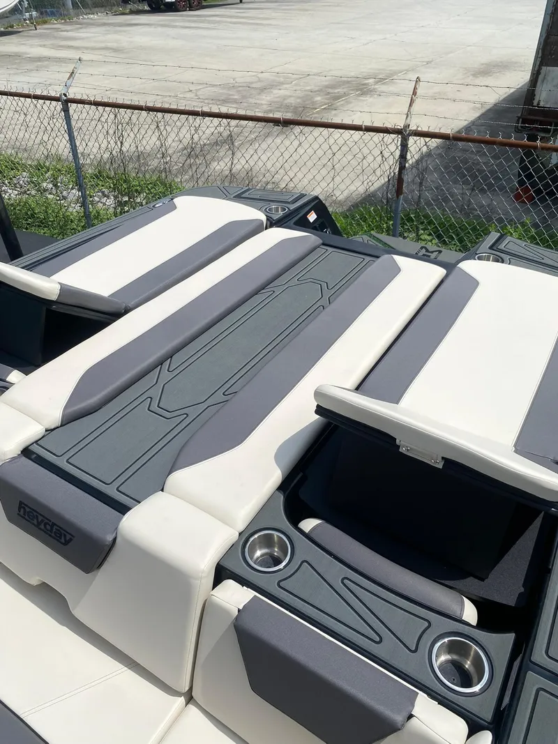 Slide: The Image of 2025 Heyday WTSurf boat interior with cushioned seating and cup holders. - 25