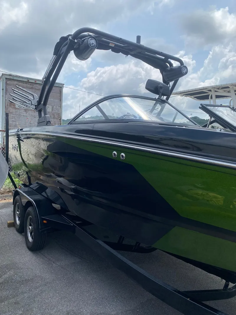 Slide: The Image of 2025 Heyday WTSurf boat with sleek black and green design on a trailer. - 4