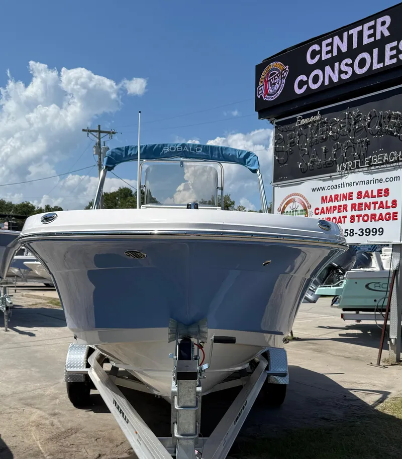 Slide: The Image of 2025 Robalo R200 Center Console boat on trailer at dealership under clear sky. - 4