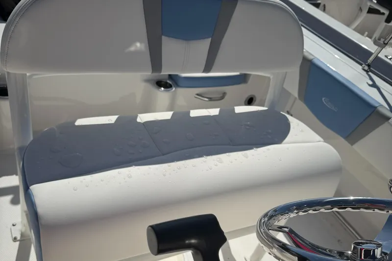 Slide: The Image of 2025 Robalo R200 Center Console boat seat with water droplets, steering wheel visible. - 8