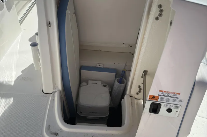Slide: The Image of 2025 Robalo R200 Center Console boat interior storage compartment with portable toilet. - 9