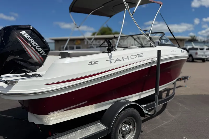 Slide: The Image of 2018 Tahoe 450TF boat on trailer with Mercury engine, parked outdoors under blue sky. - 3