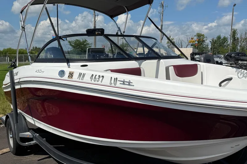 Slide: The Image of 2018 Tahoe 450TF boat with maroon and white exterior, parked on a trailer. - 5