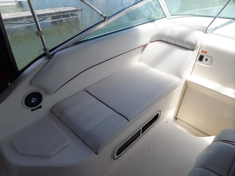 Slide: The Image of 1995 Sea Ray 250 Sundancer interior seating with white upholstery and red accents. - 13