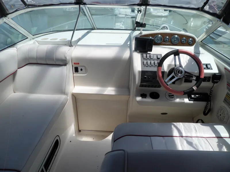 Slide: The Image of 1995 Sea Ray 250 Sundancer boat cockpit with steering wheel and control panel. - 14