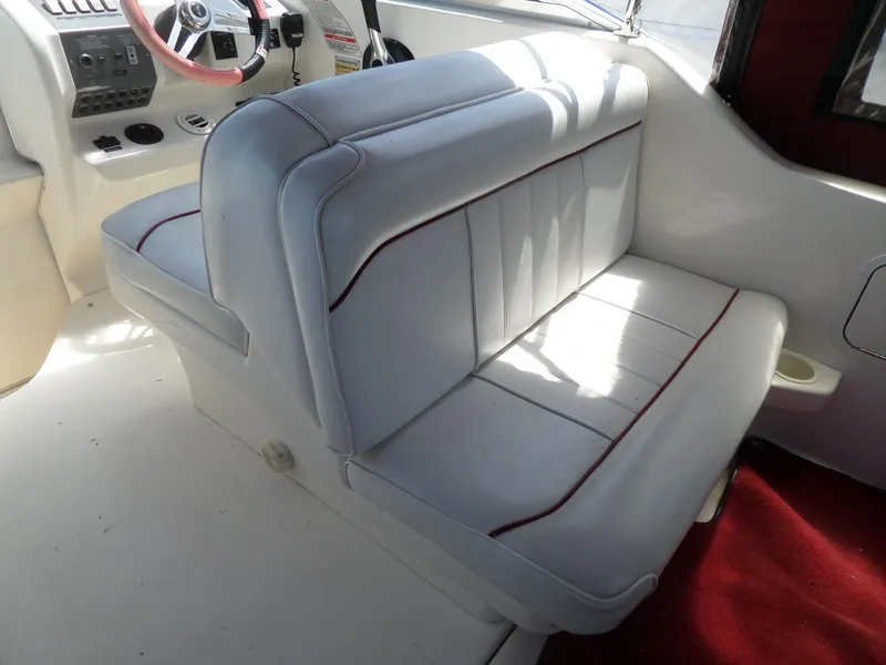 Slide: The Image of 1995 Sea Ray 250 Sundancer interior with white seating and red accents. - 15