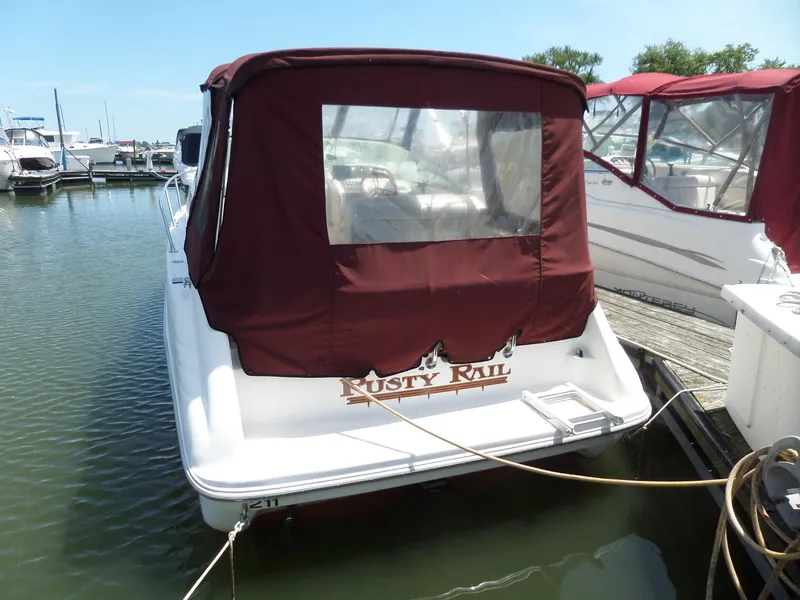 Slide: The Image of 1995 Sea Ray 250 Sundancer docked with maroon canopy, named "Rusty Rail." - 2