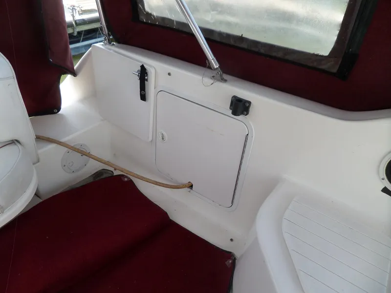 Slide: The Image of Interior of a 1995 Sea Ray 250 Sundancer boat with maroon upholstery. - 22