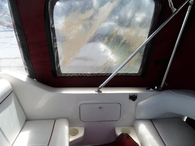 Slide: The Image of Interior of a 1995 Sea Ray 250 Sundancer boat with white seating and red accents. - 24