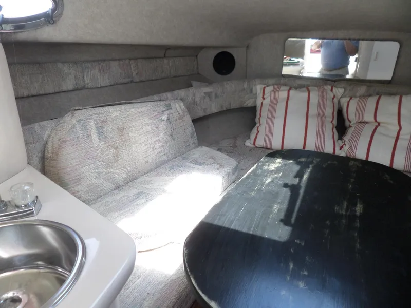 Slide: The Image of 1995 Sea Ray 250 Sundancer cabin interior with seating, table, and sink. - 26