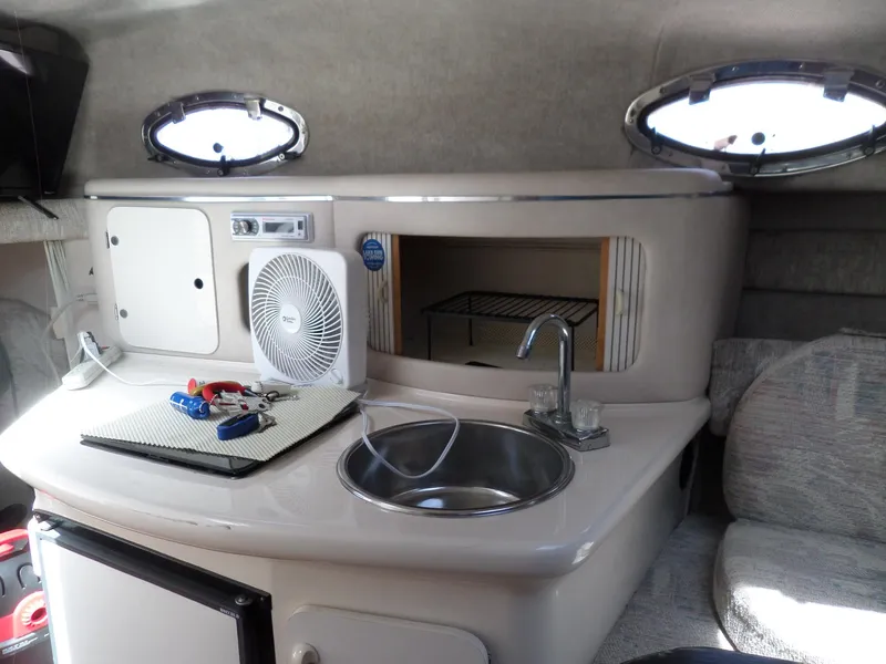 Slide: The Image of Interior of 1995 Sea Ray 250 Sundancer boat with kitchenette and portholes. - 29