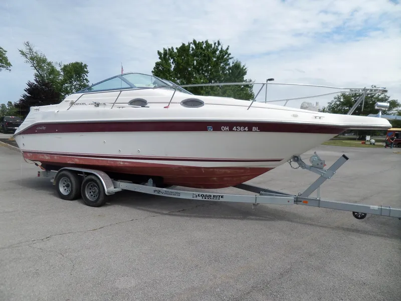 Slide: The Image of 1995 Sea Ray 250 Sundancer boat on trailer, parked outdoors, under cloudy sky. - 3