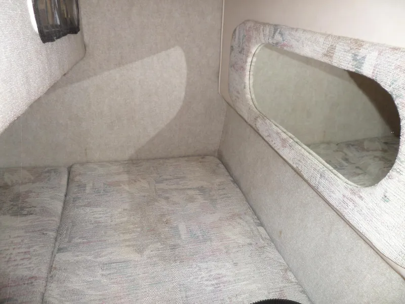 Slide: The Image of Interior cabin of 1995 Sea Ray 250 Sundancer with cushioned seating and window. - 34