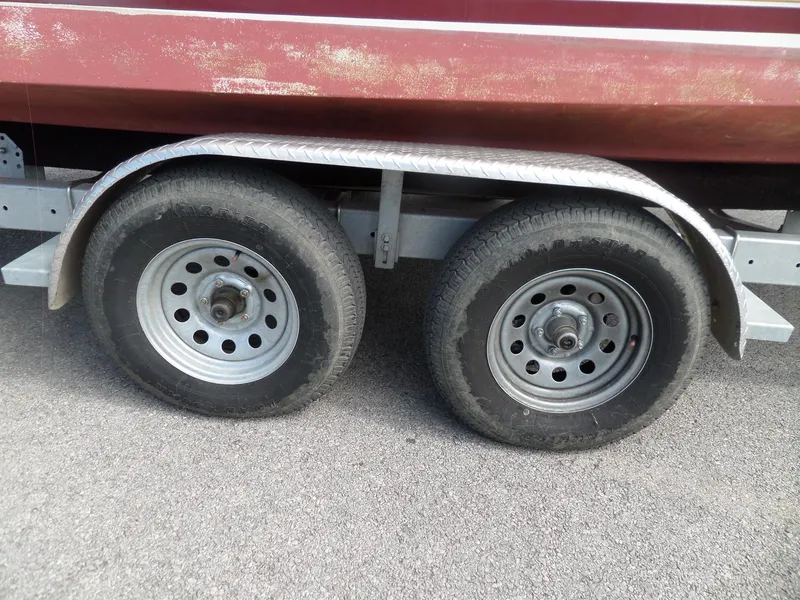 Slide: The Image of Trailer wheels of a 1995 Sea Ray 250 Sundancer boat on pavement. - 8