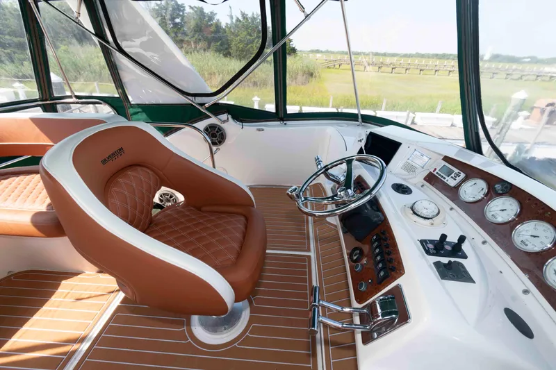 Slide: The Image of 2004 Silverton 34 Convertible helm with leather seat, steering wheel, and control panel. - 10