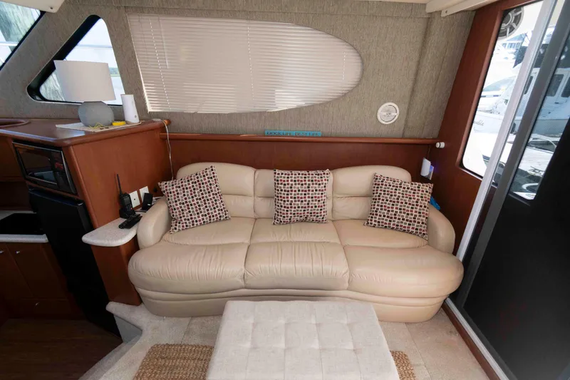 Slide: The Image of Interior of 2004 Silverton 34 Convertible yacht with beige sofa and patterned cushions. - 14