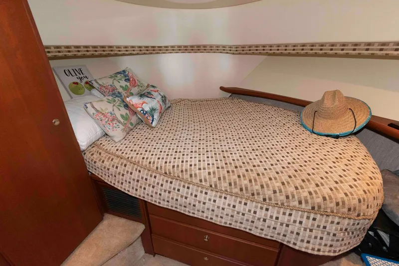 Slide: The Image of Cozy cabin bedroom in 2004 Silverton 34 Convertible with decorative pillows and a straw hat. - 20