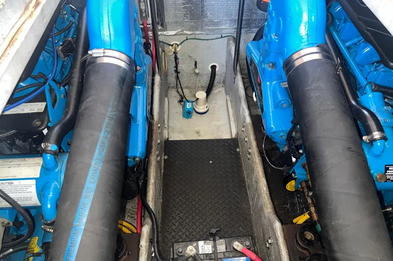 Slide: The Image of Engine room of a 2004 Silverton 34 Convertible with blue marine engines and hoses. - 24