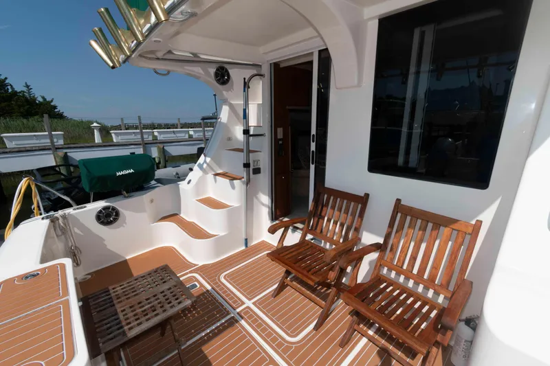 Slide: The Image of 2004 Silverton 34 Convertible yacht deck with wooden chairs and steps. - 4