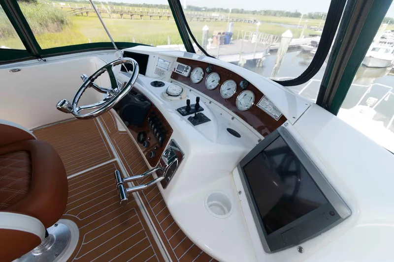 Slide: The Image of 2004 Silverton 34 Convertible yacht helm with steering wheel, gauges, and navigation screen. - 9