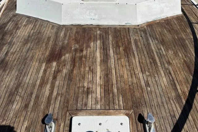 Slide: The Image of 1985 Spindrift Trawler wooden deck with metal fixtures, showcasing classic nautical design. - 13